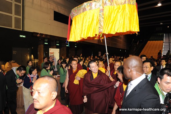 Karmapa is welcomed in the hall - in the back the KHCP-infostall